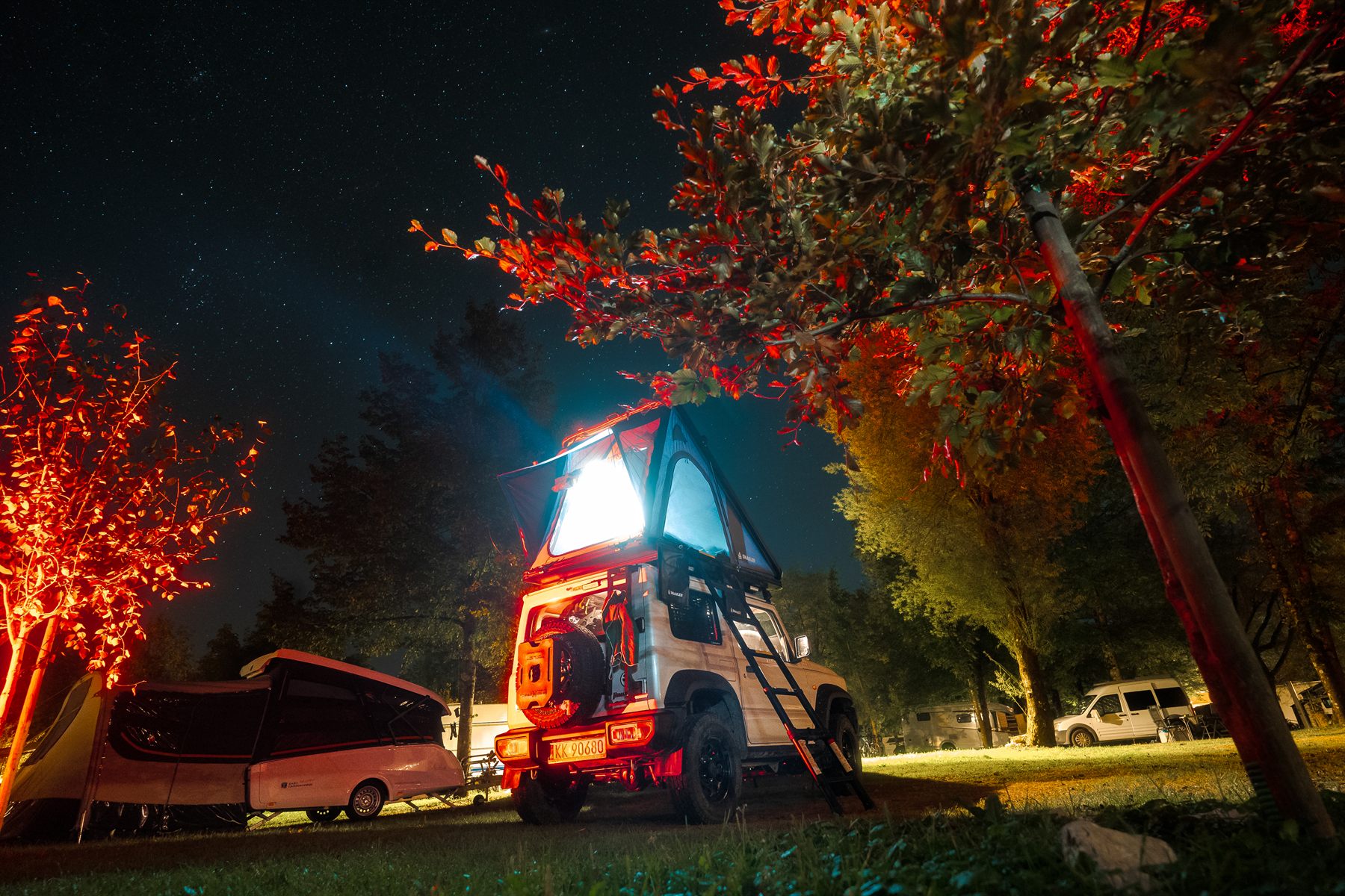 Beleuchtetes Snailer Dachzelt nachts auf einem Campingplatz